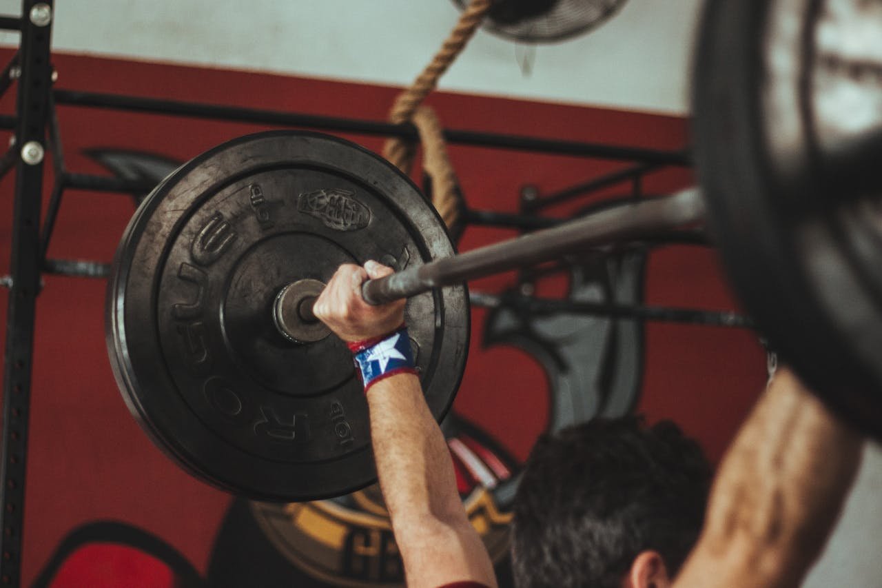 why-choose-us Athlete lifting heavy barbell during strength training session in gym.